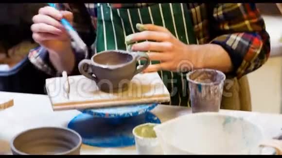 男艺术家在陶器碗上作画视频的预览图