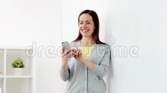 快乐的女人在家里的智能手机上发短信视频的预览图