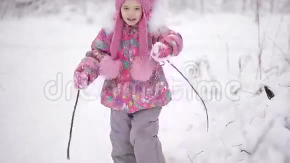 可爱的小女孩正在冬天的森林里玩雪视频的预览图