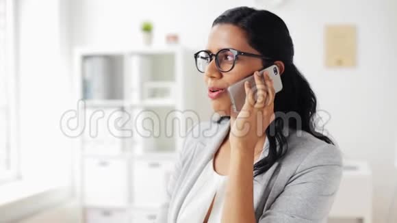 女商人在办公室用智能手机打电话视频的预览图