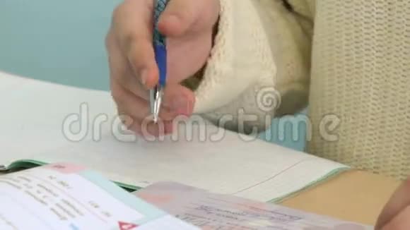 这个女孩在课堂上的笔记本上写字视频的预览图