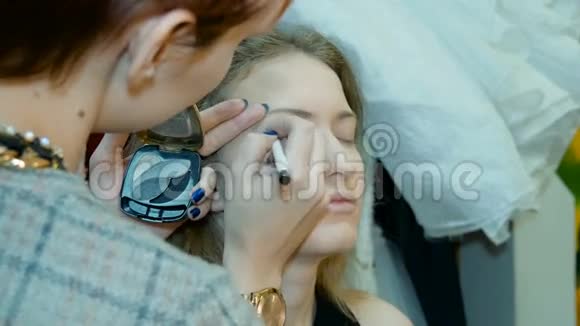专业化妆师将化妆应用于美丽的模特视频的预览图