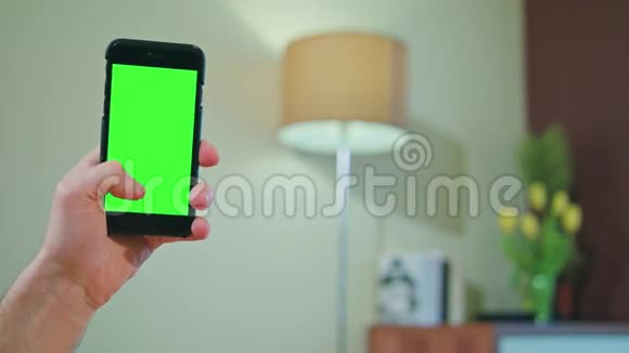 男性手拿着绿色屏幕的手机视频的预览图