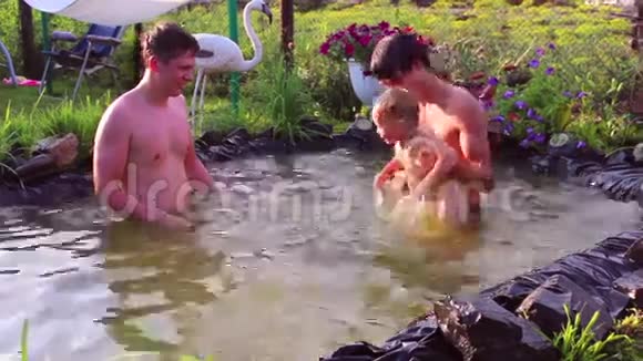 年轻人和一个小孩在池塘里玩耍视频的预览图
