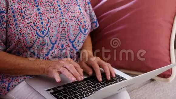 高级女性在使用笔记本电脑时微笑视频的预览图