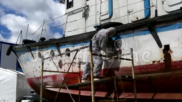 造船厂的工人在修理过程中把金属上的油漆撕掉视频的预览图