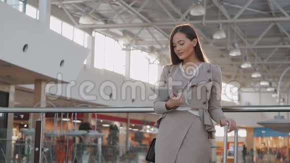 机场年轻女性乘客在等待航班时使用平板电脑视频的预览图