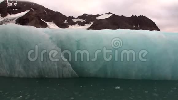 斯瓦尔巴德北冰洋水上的山脉背景上的冰浮视频的预览图