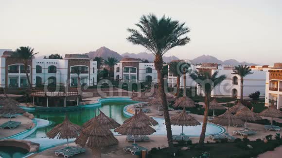 有蓝色游泳池棕榈树和日光浴床的酒店度假村视频的预览图