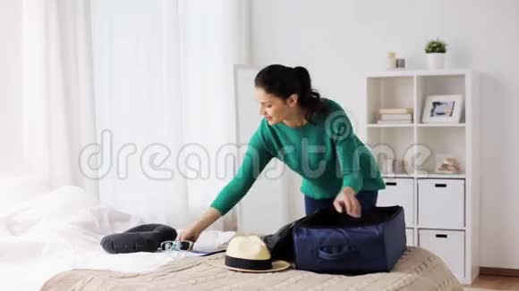女士在家或酒店房间打包旅行袋视频的预览图