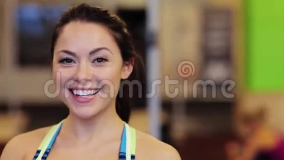 快乐微笑的年轻女子在健身房视频的预览图