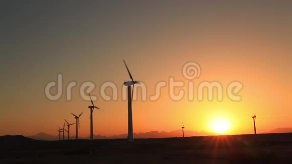 日落天空背景下的风力涡轮机视频的预览图