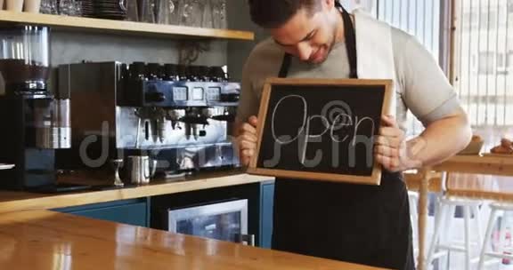 微笑的服务生展示石板和开放的标志视频的预览图