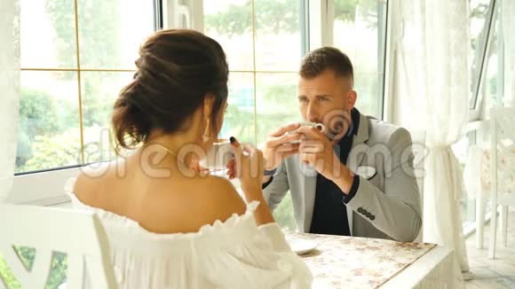 一对年轻夫妇在餐馆里微笑着交谈视频的预览图