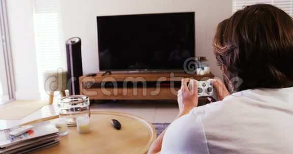 在客厅玩电子游戏的男人视频的预览图