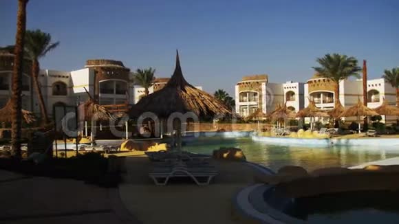 埃及阳光酒店度假村配有蓝色游泳池棕榈树和日光浴床视频的预览图