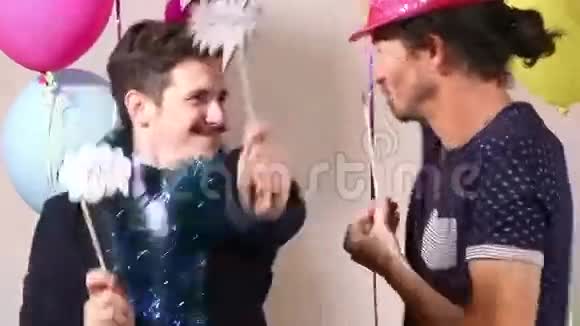 快乐的男性朋友用道具在摄影棚跳舞视频的预览图