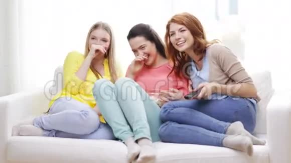 三个微笑的少女在家看电视视频的预览图