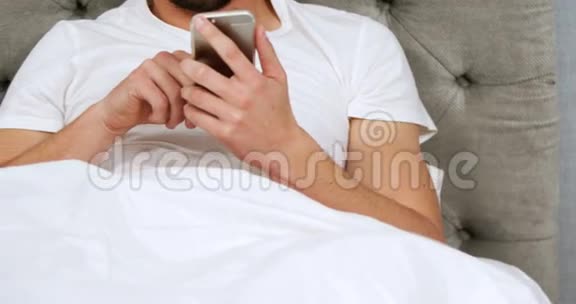 男人在卧室里用手机视频的预览图