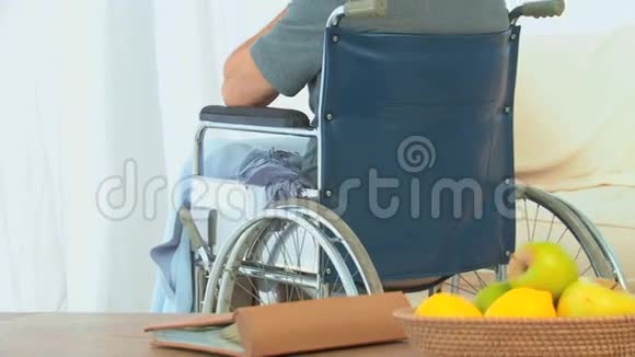 坐轮椅的男人透过窗户看视频的预览图