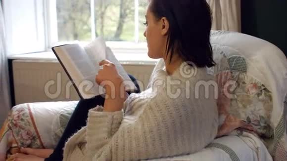 漂亮的女人在卧室里读小说视频的预览图