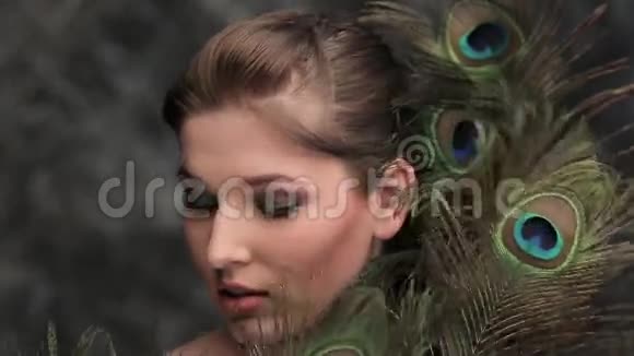彩妆和孔雀羽毛的女孩视频的预览图