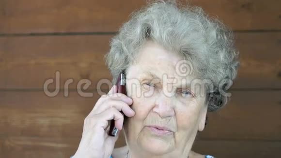 在智能手机上说话的老年妇女视频的预览图