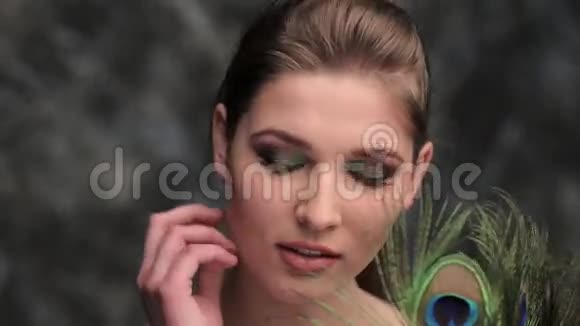 彩妆和孔雀羽毛的女孩视频的预览图