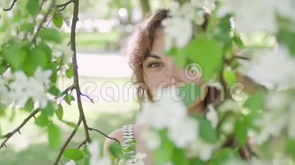 年轻女子在树的背景下享受视频的预览图