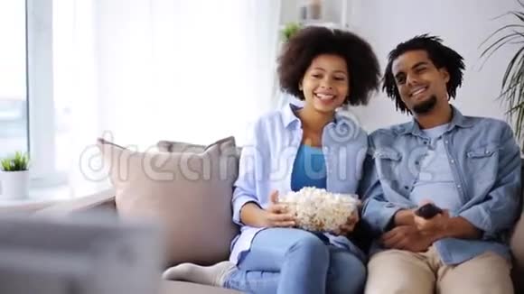 笑眯眯的爆米花夫妻在家看电视视频的预览图