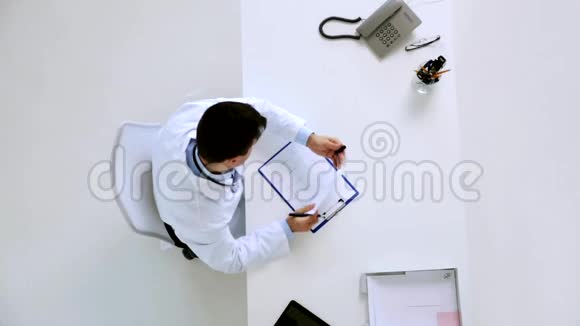 医生在诊所用剪贴板记录心电图视频的预览图