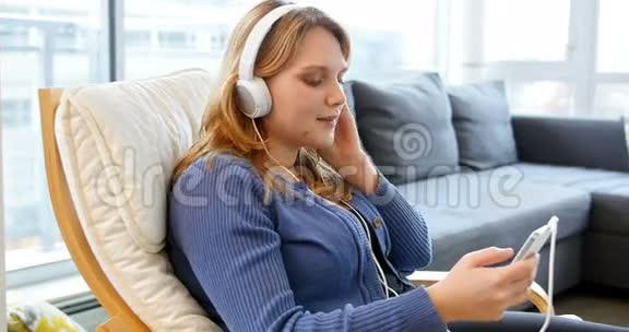 女人在手机上听音乐视频的预览图
