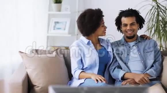 快乐微笑的夫妇在家看电视视频的预览图
