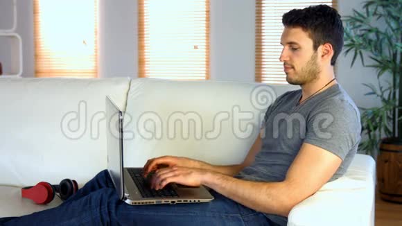 他在沙发上用笔记本电脑视频的预览图