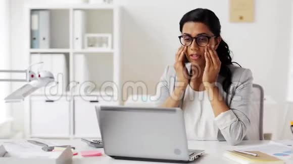办公室里戴眼镜的女商人很累视频的预览图