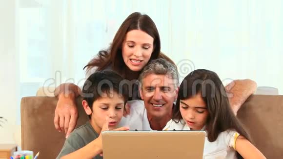 一家人看着笔记本电脑视频的预览图