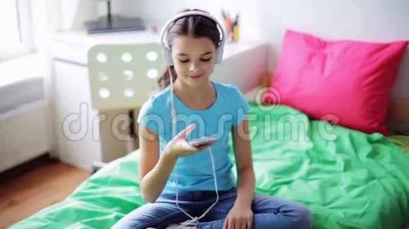家里带着智能手机和耳机的快乐女孩视频的预览图