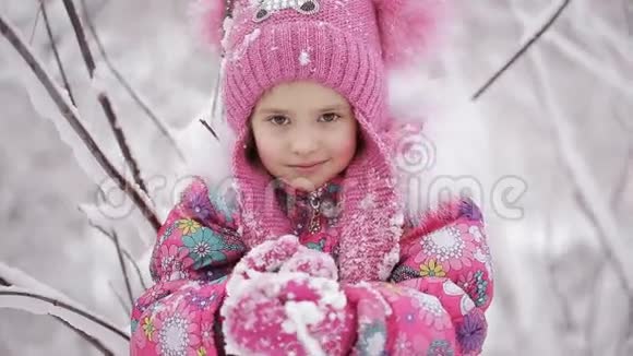 可爱的小女孩正在冬天的森林里玩雪视频的预览图
