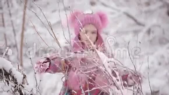 可爱的小女孩在冬天的森林里玩雪视频的预览图