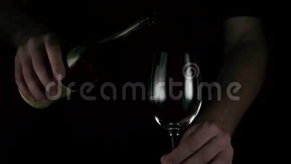 将葡萄酒倒入黑色背景的玻璃杯中视频的预览图