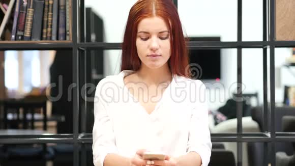 美丽的女人在智能电话室内视频的预览图