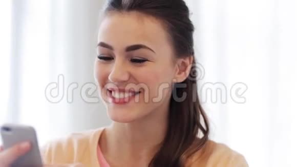 快乐微笑的年轻女人带着智能手机视频的预览图