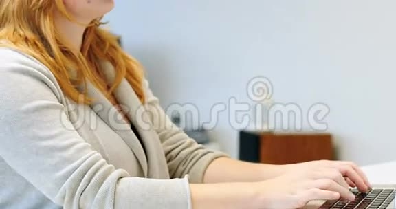 在笔记本电脑工作时使用虚拟现实耳机的女性视频的预览图