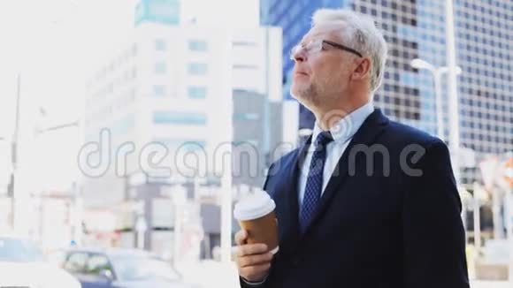 城市大街上喝咖啡的高级商人视频的预览图