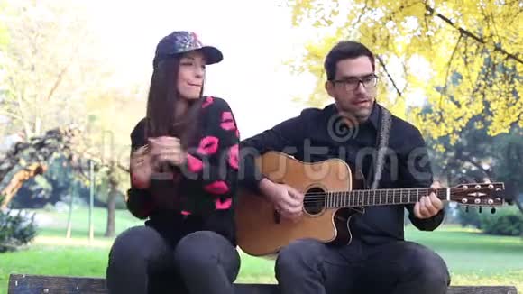 年轻的黑发女人在唱歌而帅哥在弹吉他视频的预览图