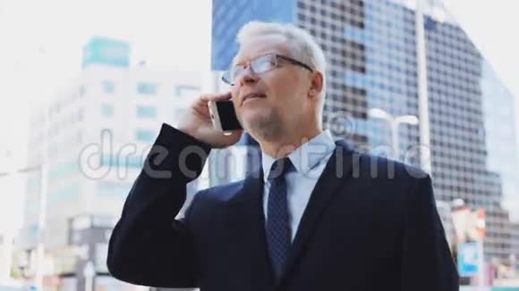 城市里打电话给智能手机的高级商人视频的预览图
