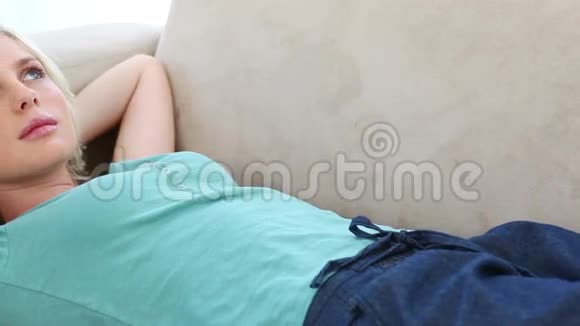 年轻的女人躺在沙发上视频的预览图