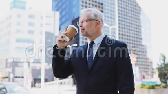 城市大街上喝咖啡的高级商人视频的预览图