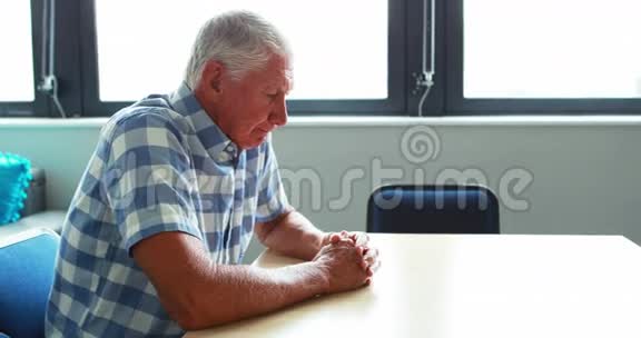 一位坐在桌旁思考着视频的预览图