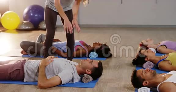 女教练协助男子练习瑜伽视频的预览图